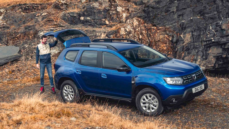 Man looks in boot of Dacia Duster parked in the wilderness