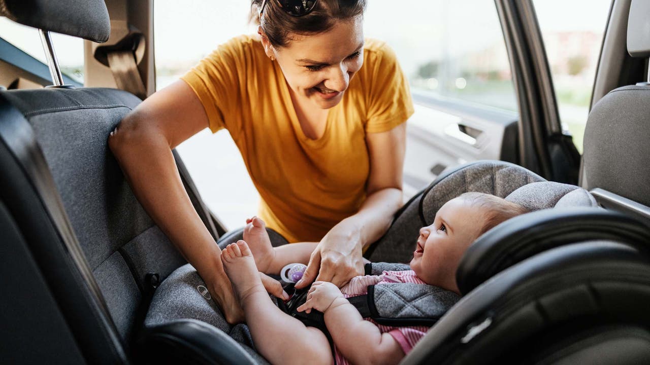 Lady looking at baby in car seat