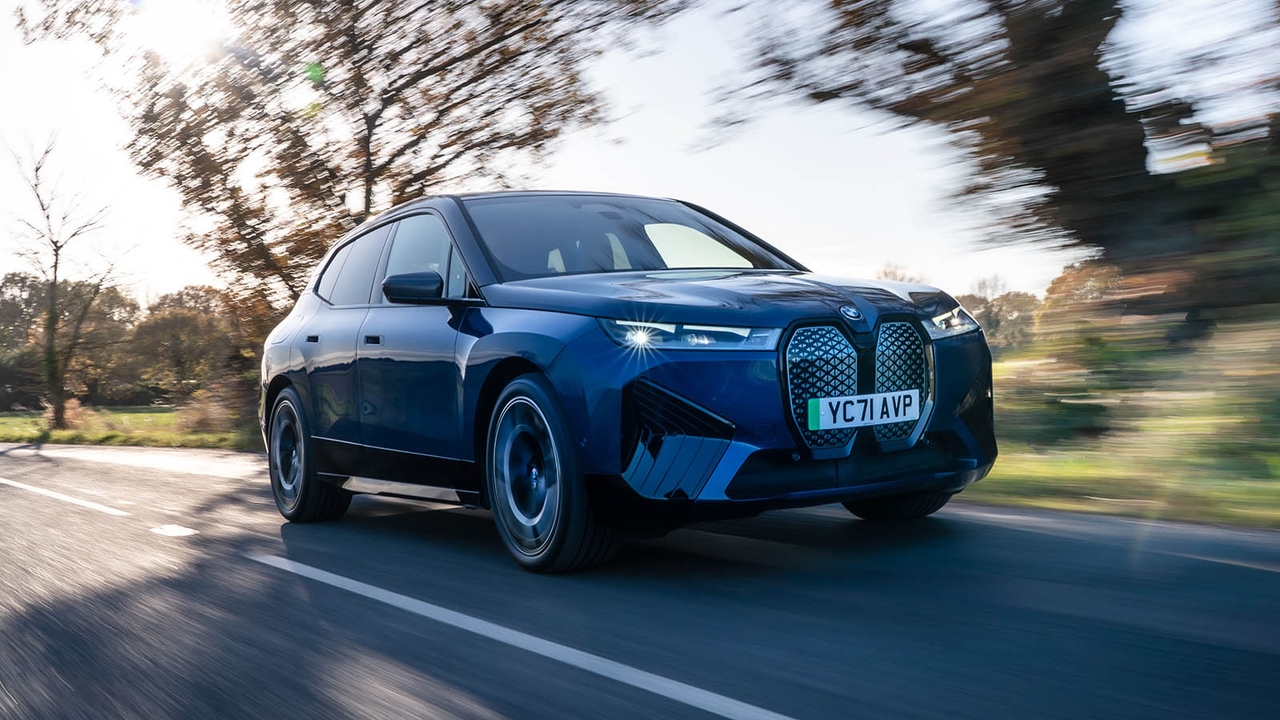 BMW iX in blue, front three quarter driving shot