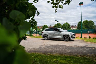 Skoda Karoq parked next to a tennis court