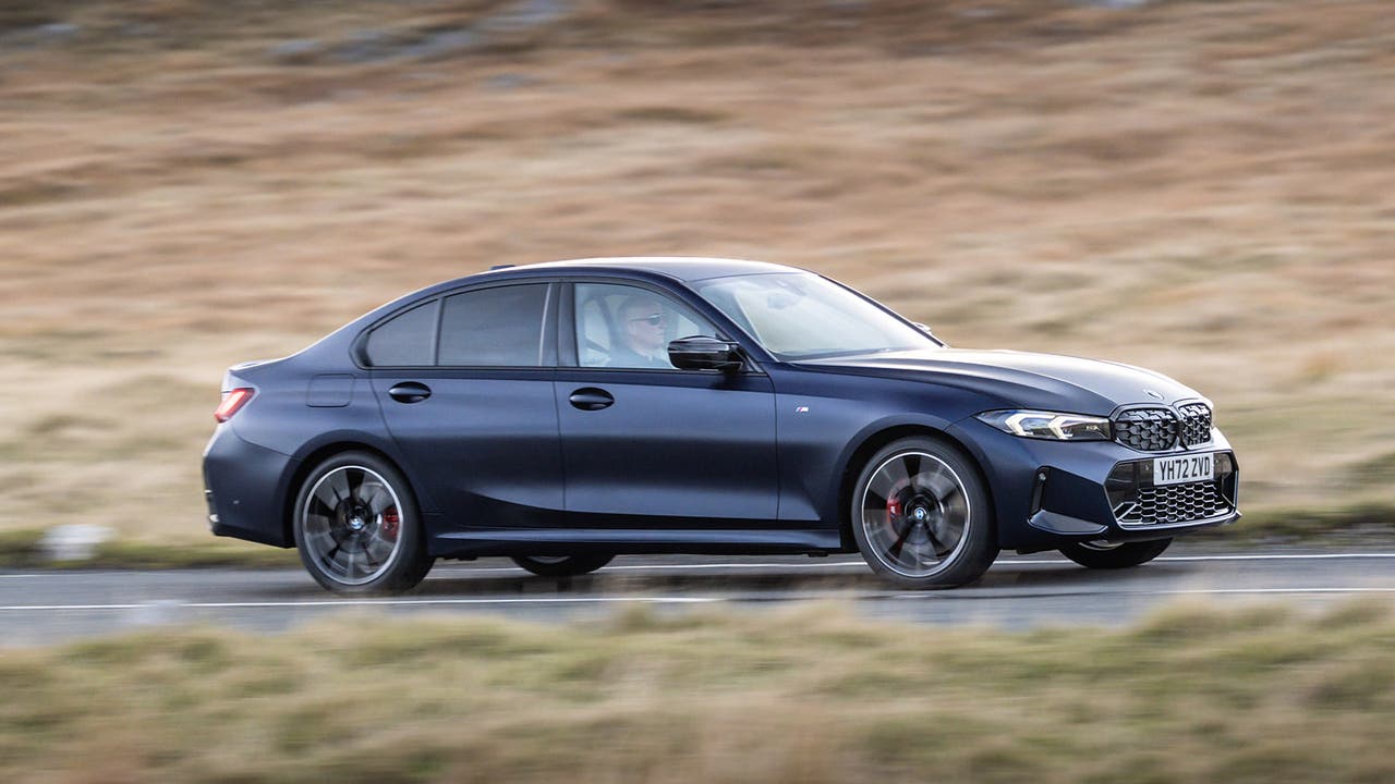 BMW 3 Series saloon in dark blue, driving shot.