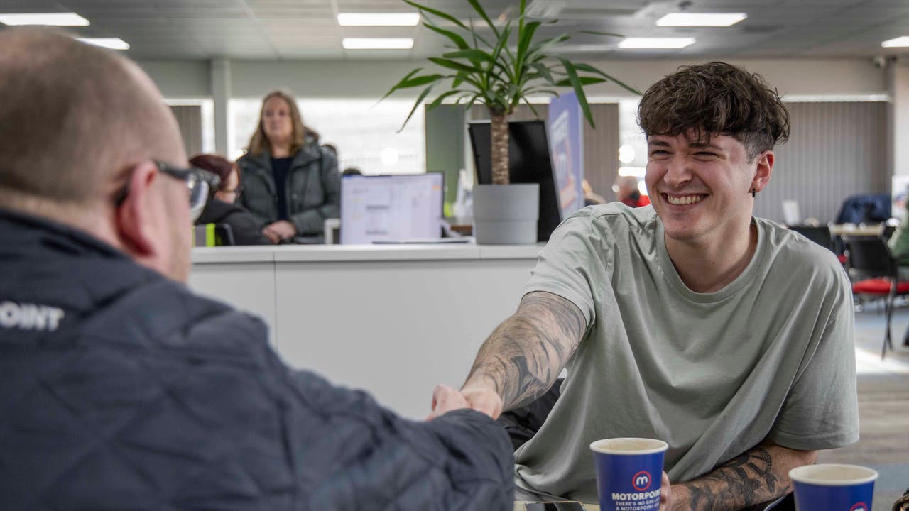 Happy Motorpoint customer shaking hands with salesperson