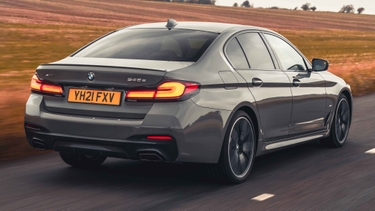 BMW 5 Series driving, rear view