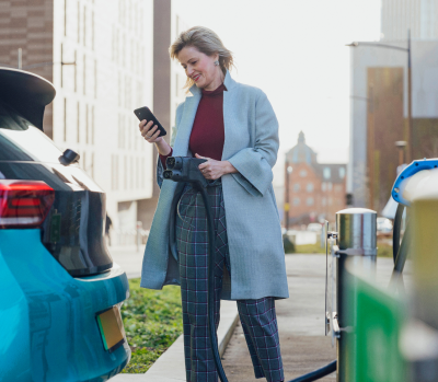 Woman using public charging to charge her EV