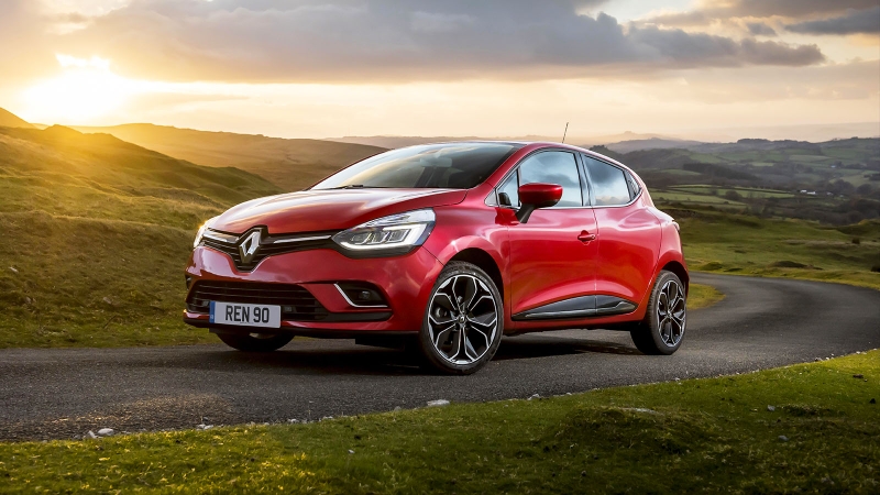 Renault Clio in red with sun glaring behind it