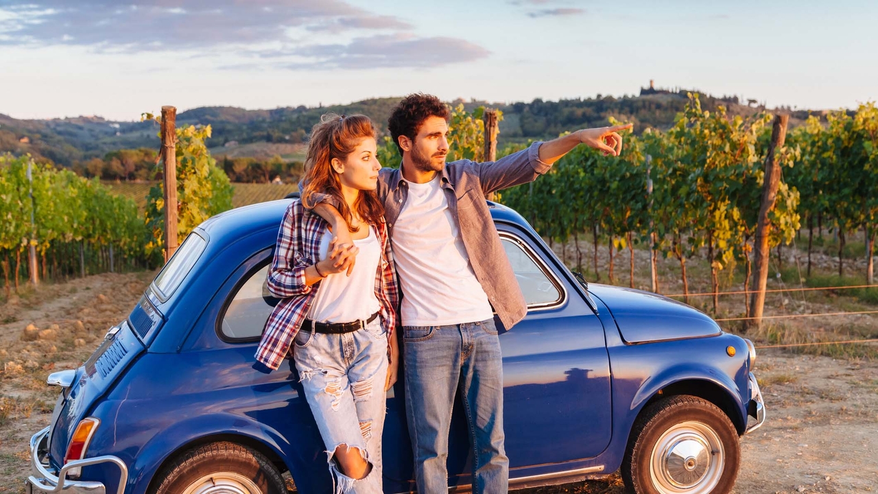 Couple in a vineyard next to a classic Fiat 500