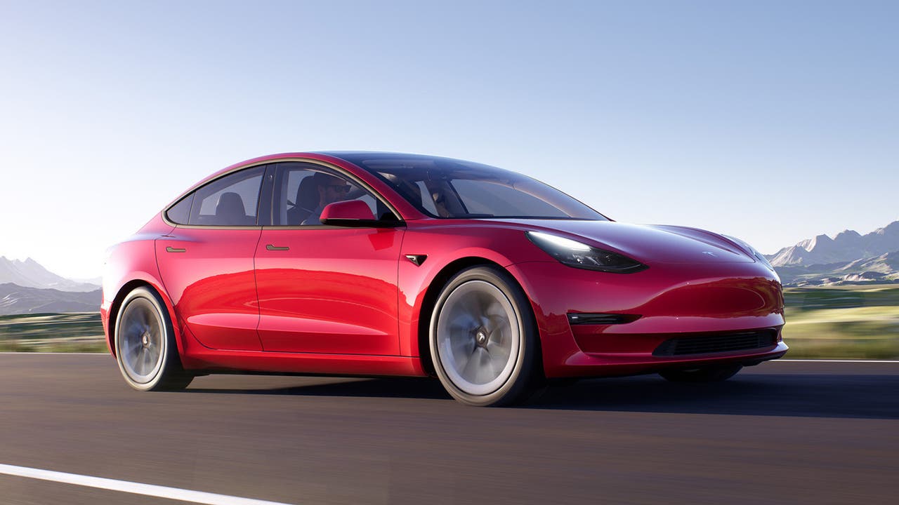 Tesla Model 3 in red, driving shot