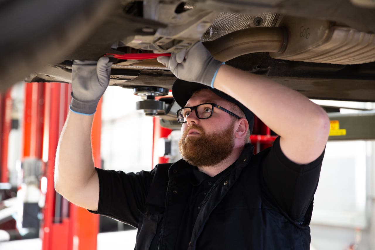 Man works on car underneath it