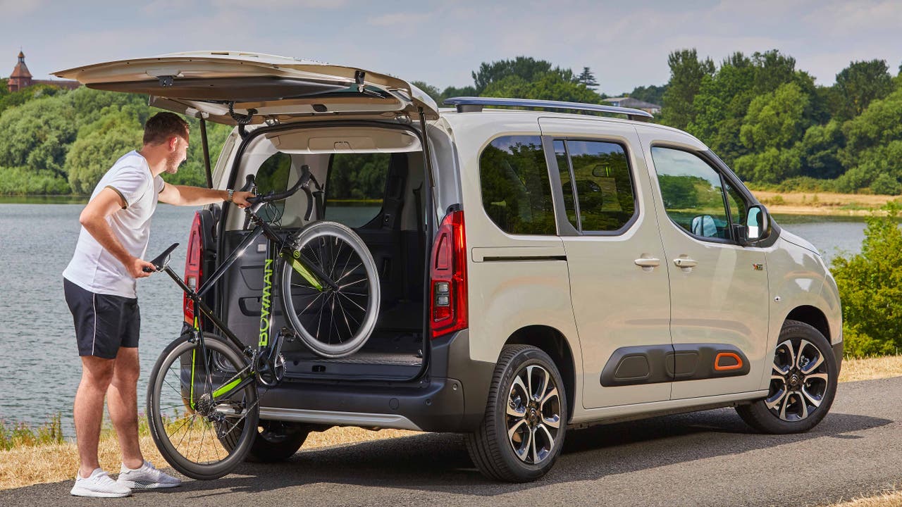 Man loading a bike into a Citroen Berlingo