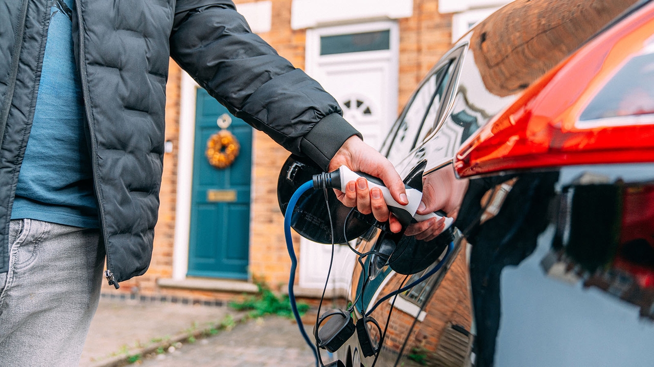 Person charging an EV from a home socket