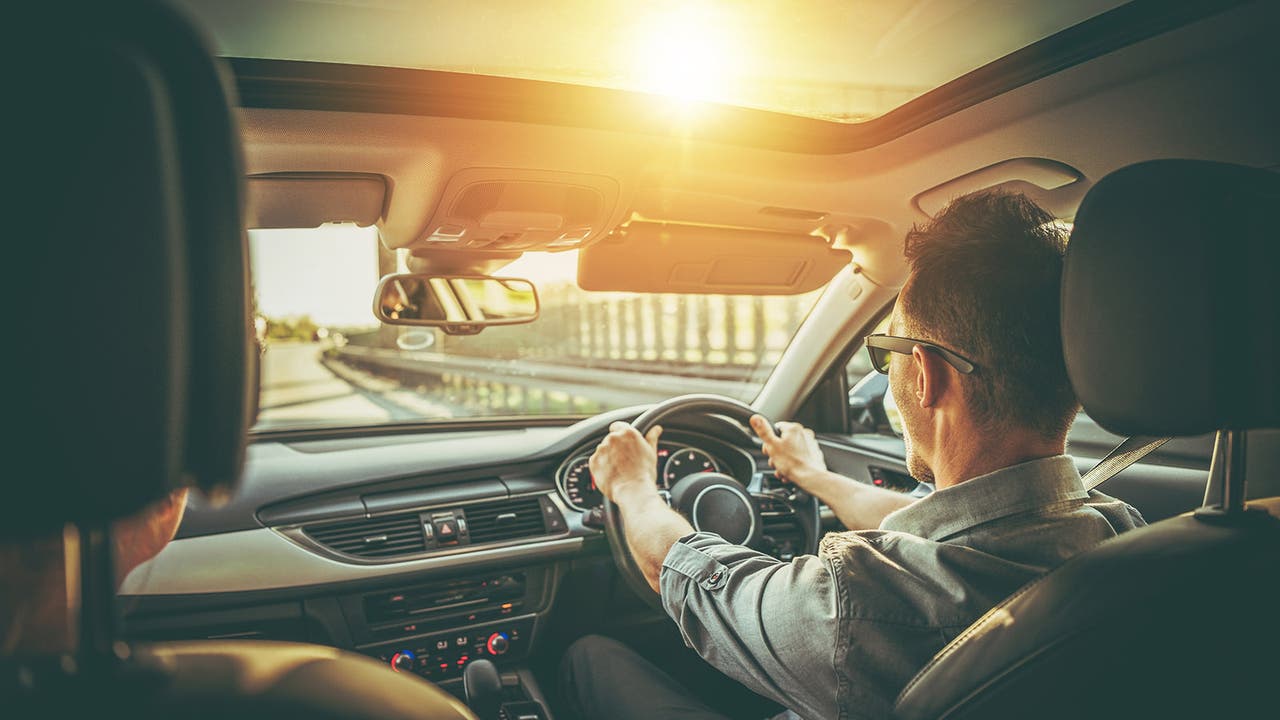 Driver wears sunglasses while driving in sunshine