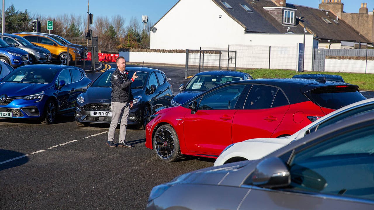 A Motorpoint salesperson interacting with vehicles at a Motorpoint store