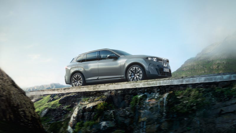BMW iX5 in grey, driving over a bridge