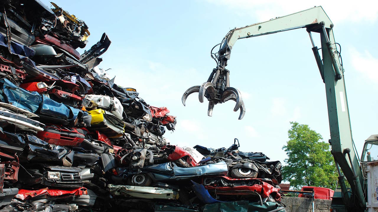 A crane with a pile of crushed cars