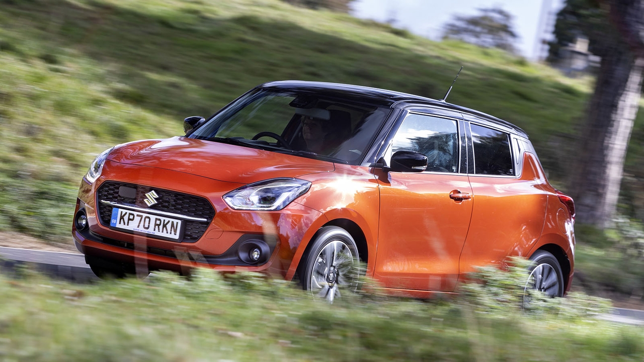 A Suzuki Swift in orange, driving shot