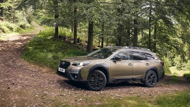 Subaru Outback driving up a forest trail