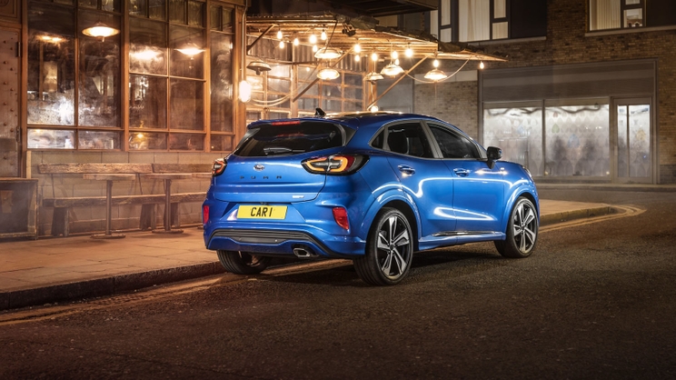 The rear of a blue Ford Puma lurking on an urban street