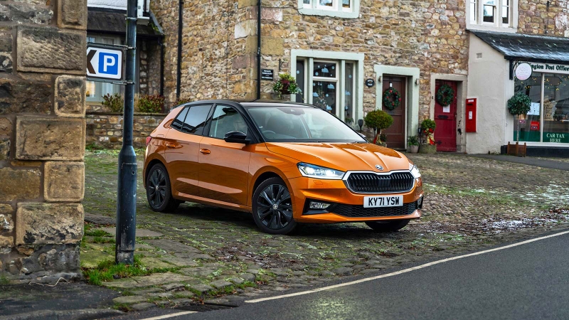 Skoda Fabia in orange, static shot in a village