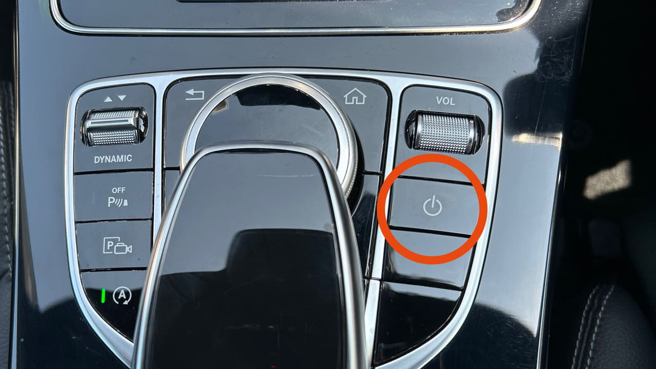 Mercedes C-Class, how to turn on media. Stereo controls on centre console with on/off switch circled.