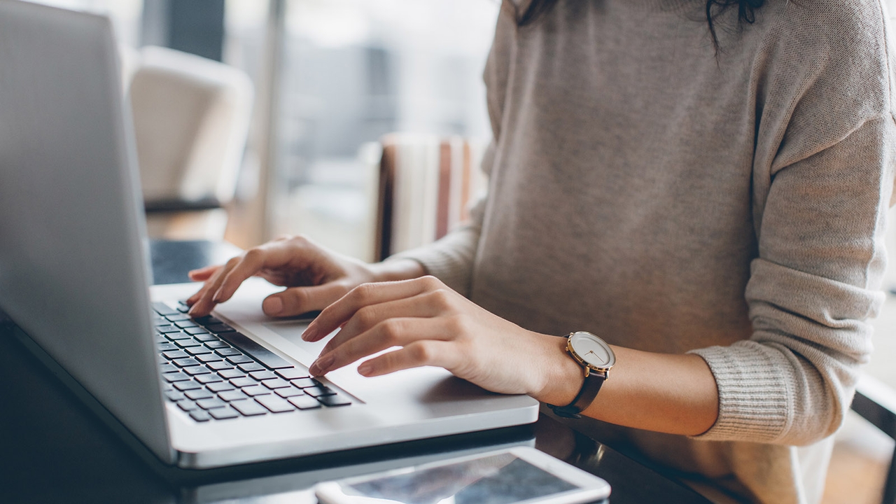 Lady typing on a computer, comparing the purchase price of a car against its guaranteed future value to get an idea of its depreciation rate