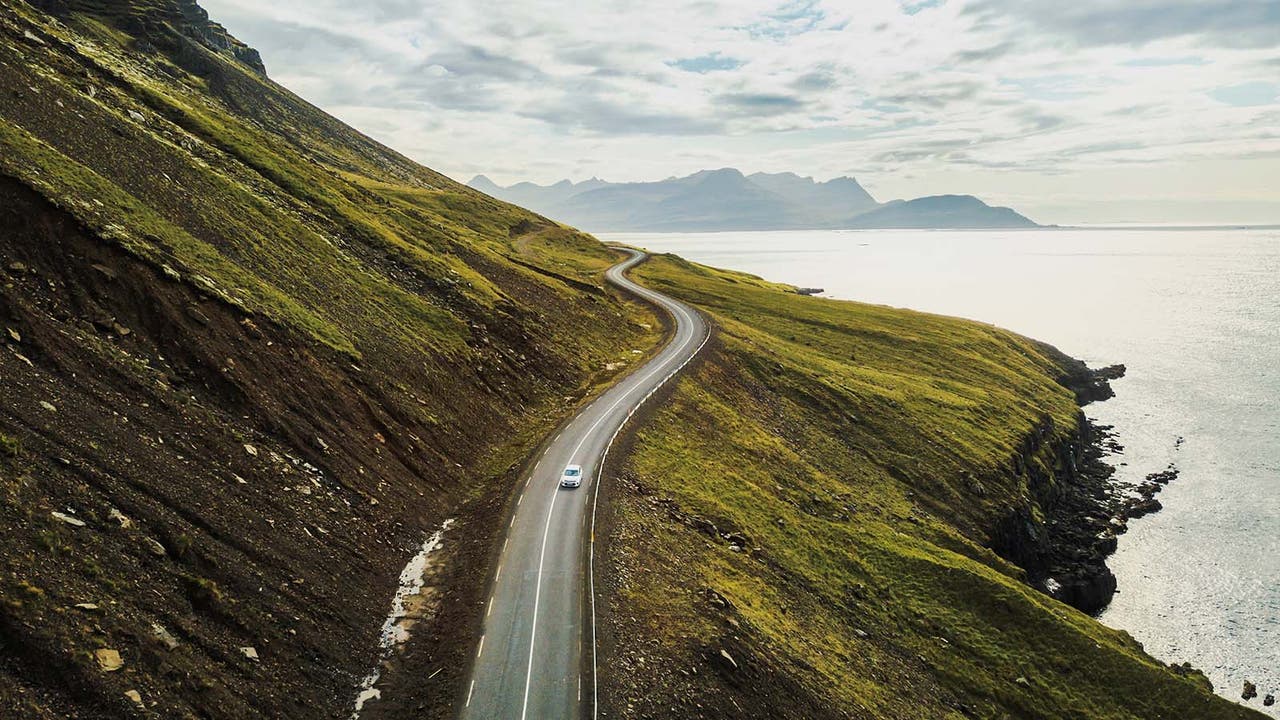 Car driving in the distance on a pretty coastal road