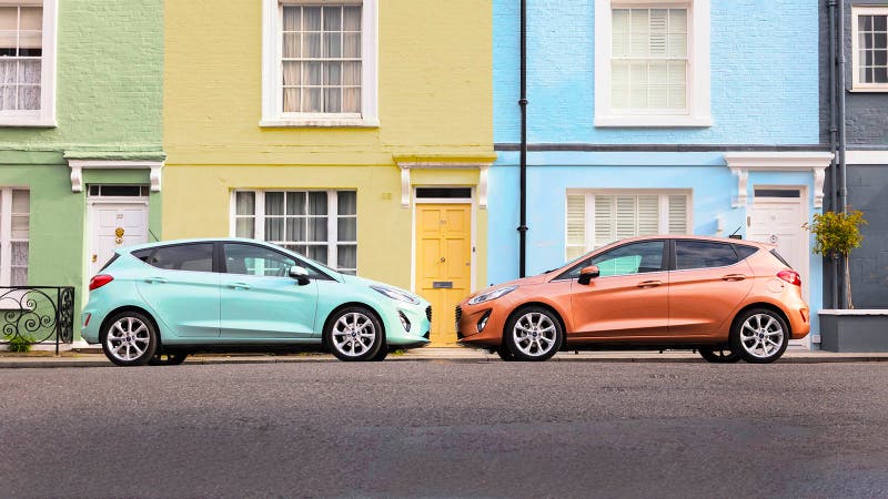 Two Ford Fiestas side-on parked nose to nose, one turquoise, one orange