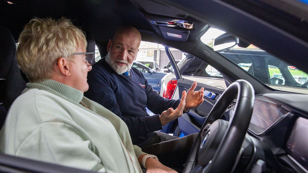 Motorpoint sales executive explains something to a customer sat in a car's interior