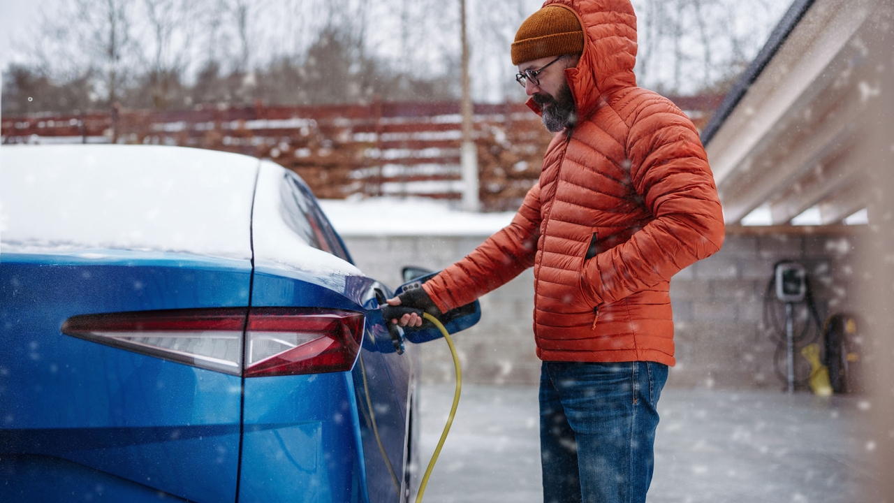 Man charging an electric Skoda in cold weather