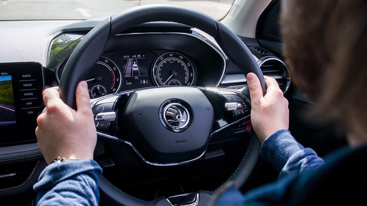 Young driver holding a Skoda Fabia steering wheel