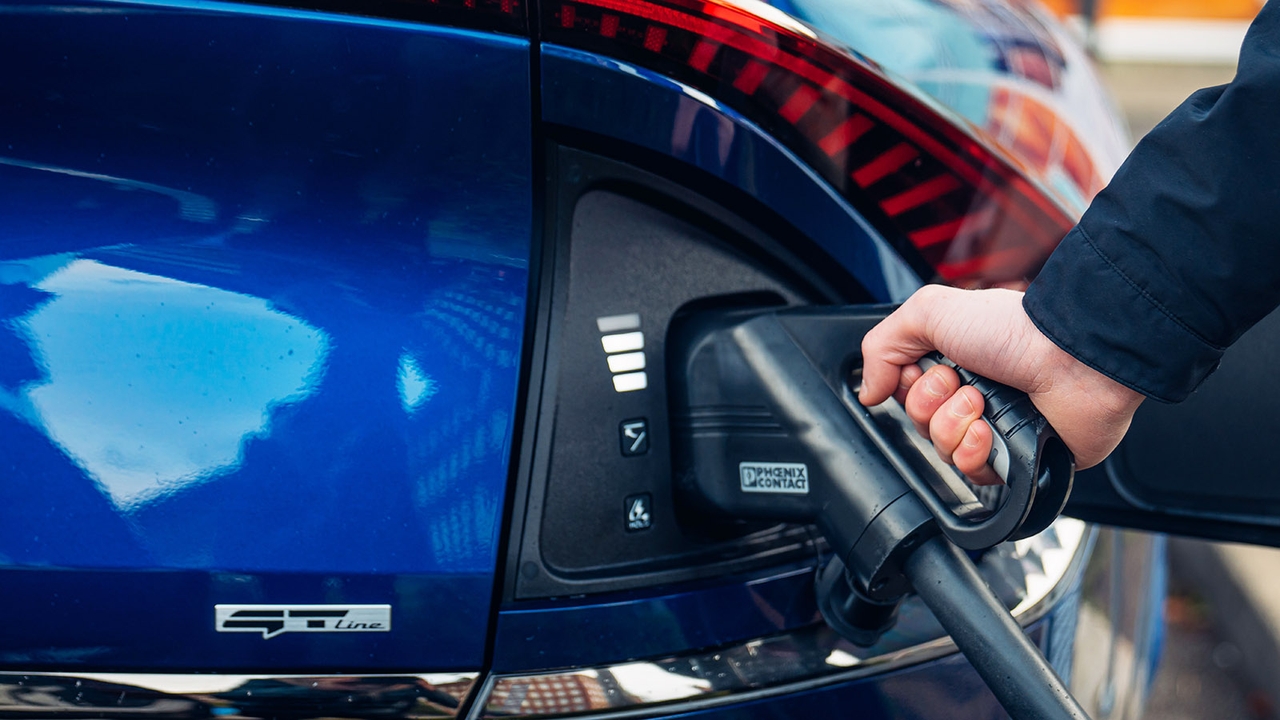 Kia EV6 being plugged in with exterior charge indicator showing