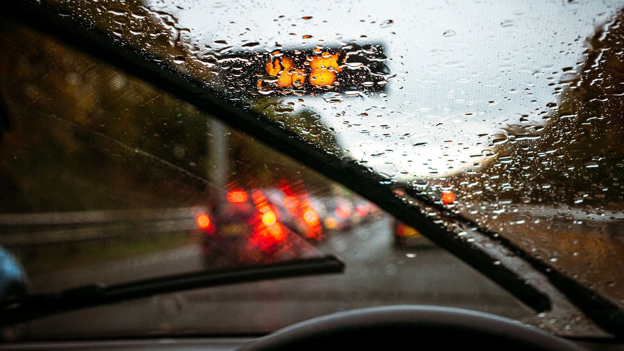 Wet motorway with queueing traffic seen through a windscreen