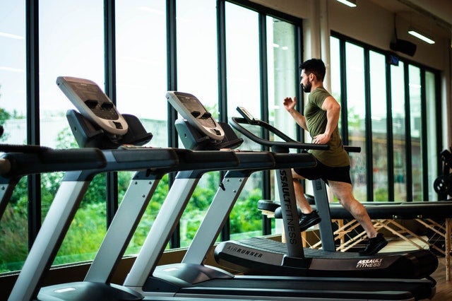 Man looking out the window while running on a treadmill