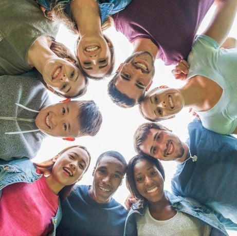 group of people looking down and smiling in a circle