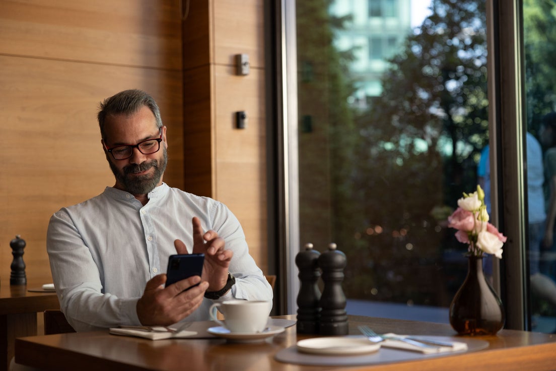 A man booking a pensions appointment on his phone.